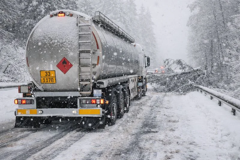 Chemical transport truck delayed by weather conditions, illustrating potential supply chain disruptions.