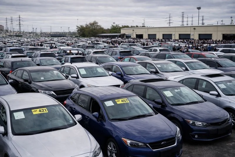 Large car auction lot with many vehicles showing high demand and competition for transport