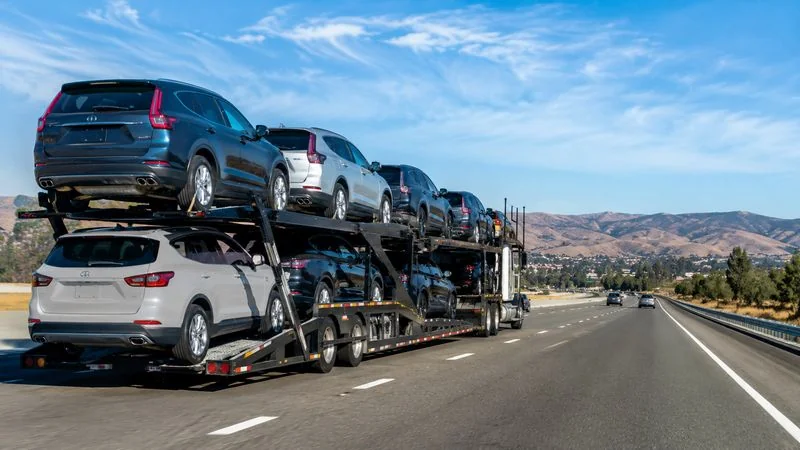 Multi-vehicle carrier transporting cars on a highway as part of the vehicle shipping process