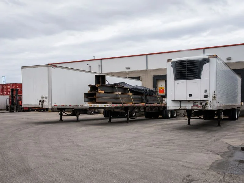 Dry van, flatbed, and refrigerated freight trailers at a logistics facility